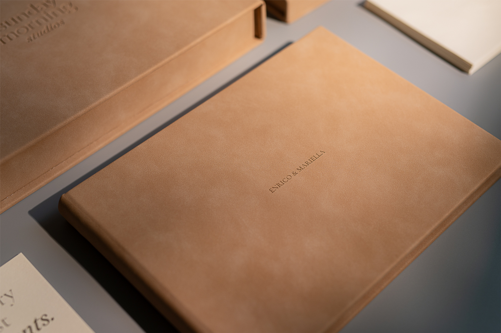 The Storybook, a wedding book by Sunday Morning Studios, closed and placed on a gray background.