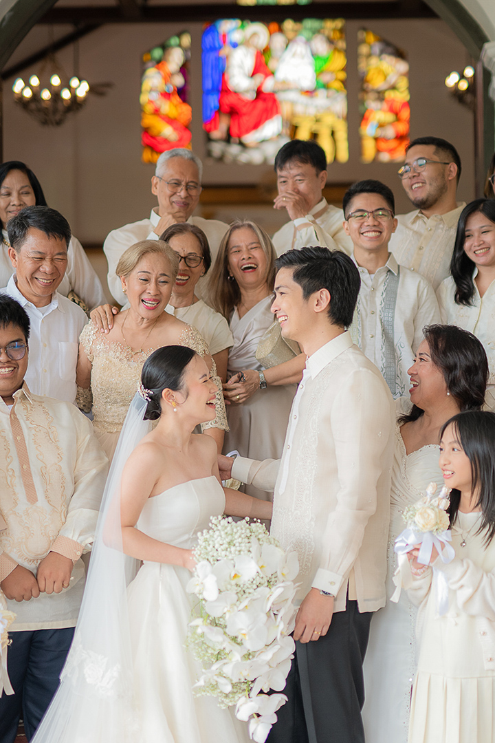 Happy newly married couple surrounded by ther happy guests.